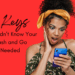 Woman of color looking down at her phone with her hand up to her cheek with a shocked expression. she has curly hair and she's wearing a floral off the shoulder top in front of a red back ground. the text is about tips you didn't know your wash and go needed.