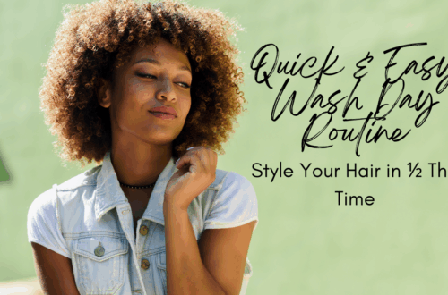 woman with a brown curly afro smiling and touching her hair against a green back ground.